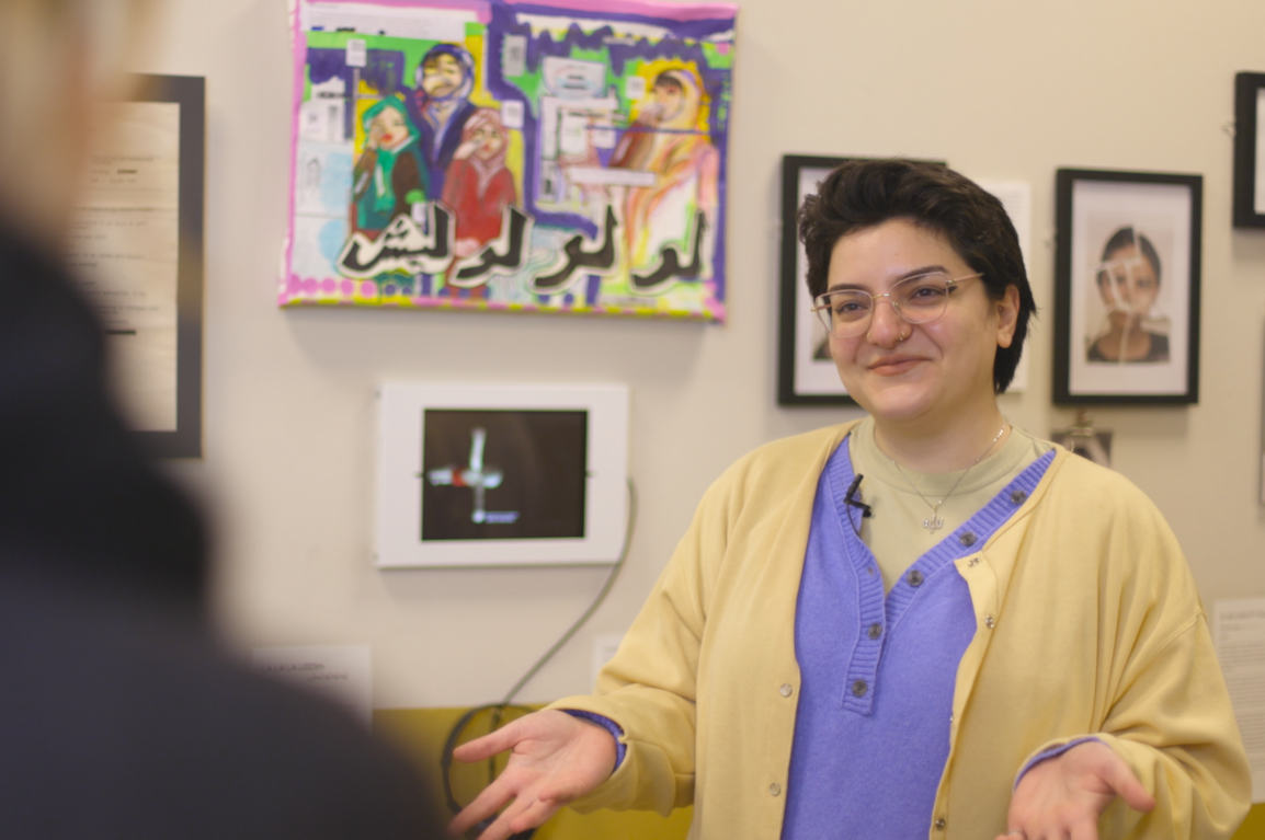 Mariam Hussein with her artwork Lo Lo Lo Leesh, displayed in the community gallery space at the Migration Museum in Lewisham, London. Photography by Felix Ursell.